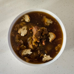 Hearty beef soup with torn bread croutons
