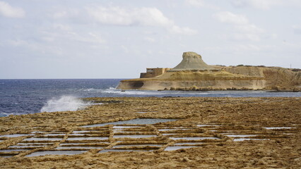 Coastal view over Malta&rsquo;s horizon, capturing vivid skies, golden reflections on the sea, and silhouetted landscapes