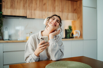 Young caucasian woman enjoying music on wireless headphones at home	