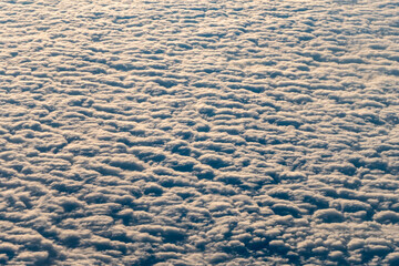 Aerial photograph showcasing an expansive, textured cloud cover. The clouds appear dense and uniformly spread, forming a soft, wavy pattern. over the Rancho Cucomonga valley from Altitude