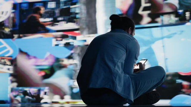 Desperate guy staring at phone screen in misery symbolizing toxic social media overuse. Obsession and excessive information affecting the mental health, anxiety and depression. Camera A.