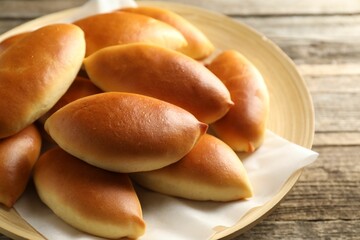 Tasty baked patties on wooden table, closeup