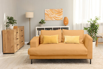 Stylish living room with comfortable sofa and light grey wall. Interior design