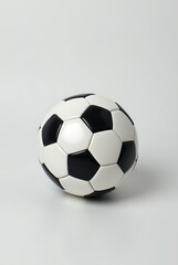 A classic black and white soccer ball on a plain white surface background look