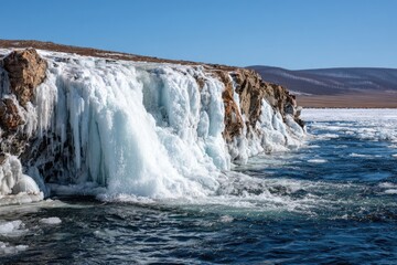 Icy waterfall cascading over frozen cliff into a lake