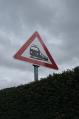 A red and white sign with a train on it is on a pole