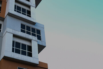 Bangunan Tinggi Modern dengan Jendela Geometris dan Latar Belakang Langit Bersih