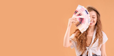 Female interior designer holding color palettes on beige background with space for text