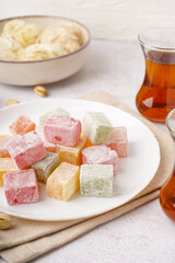 Plate with tasty Turkish Delight on light background, closeup