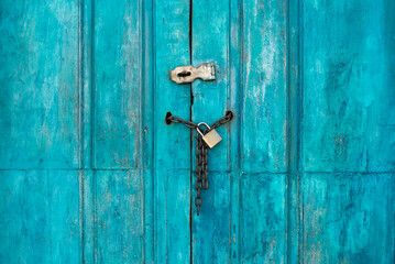 Old blue door locked with chains and padlock