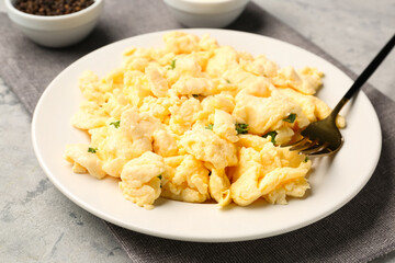 Plate of scrambled eggs on grunge background