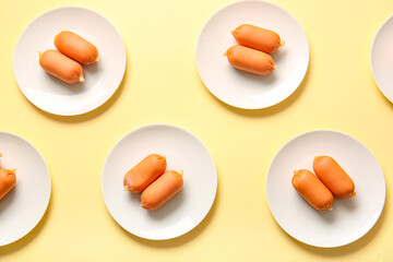 Plates of tasty boiled sausages on beige background