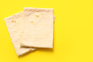 Fresh thin lavash on yellow background