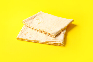 Fresh thin lavash on yellow background