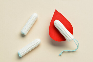 Composition with menstrual tampons and blood drop made of paper on light background, closeup