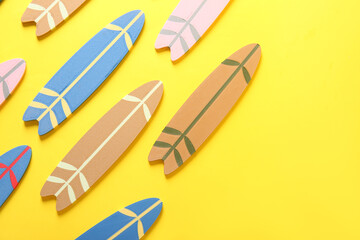 Many different colorful mini surfboards on yellow background