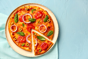Plate with tasty pizza and towel on blue background