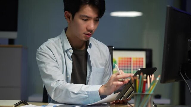 Male coder or developer working overtime using a computer display in problem solving at workplace.