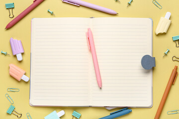 Blank notebook with school stationery on color background