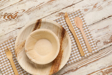 Different tableware on light wooden background