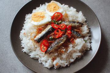 Delicious steamed rice topped with stir fried sardines, boiled eggs, and fresh chilies