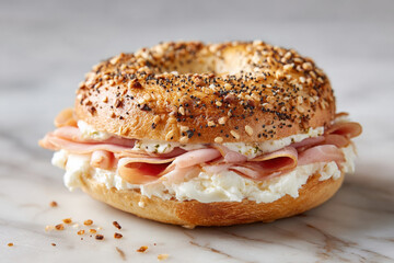 Toasted bagel with cream cheese and smoked ham, topped with seeds, perfect for breakfast