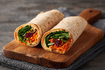Fresh whole wheat wrap filled with hummus, spinach, and shredded carrots, perfect for healthy