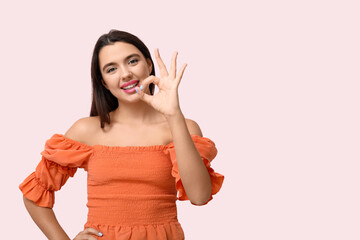 Beautiful young happy woman on pink background