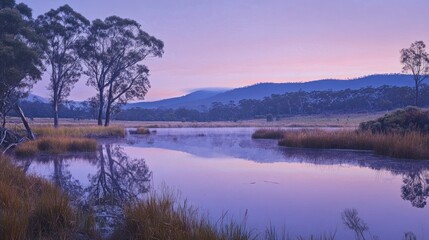 Obraz premium Serene dawn landscape with tranquil lake reflecting purple sky and trees.