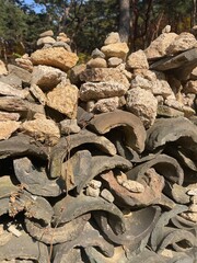 Stacked Stones and Curved Roof Tiles in Nature.
Stone Cairns on Traditional Roof Tiles in Nature.