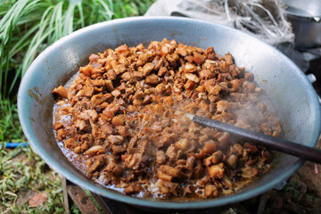 Stir-fried pork with soy sauce in a large pan.