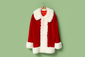 Santa Claus suit on hanger near green wall in room