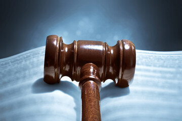 Closeup of judge gavel and open book on dark background