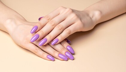 Naklejka premium A close-up of a woman's hand showcasing elegantly manicured purple nails, resting gently on a soft, textured surface, with delicate rings adorning her fingers.