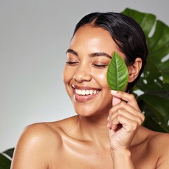 A woman stands outdoors, gently holding a vibrant green leaf to her face, her expression thoughtful as sunlight filters through the trees around her.