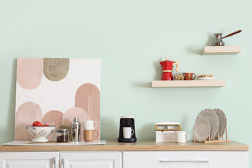 Interior of kitchen with counters, coffee machine and painting