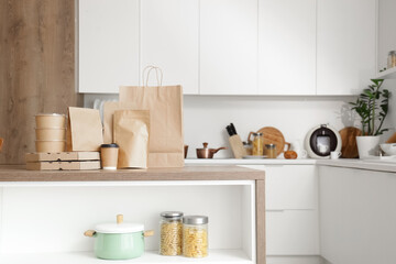 Paper bags with coffee cup on table in kitchen. Food delivery service