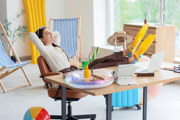 Happy businesswoman relaxing in office before vacation