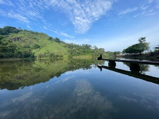 The beautiful Claket Lake reflects hills and clouds like a mirror. Its calm, clear water creates a stunning scene, blending sky and nature in perfect harmony.