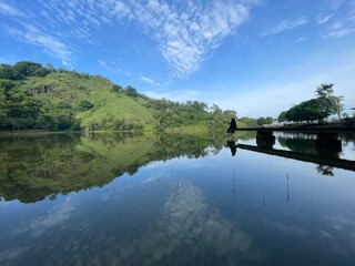 The beautiful Claket Lake reflects hills and clouds like a mirror. Its calm, clear water creates a stunning scene, blending sky and nature in perfect harmony.