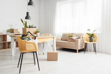 Interior of office with workplace, sofa and boxes on moving day