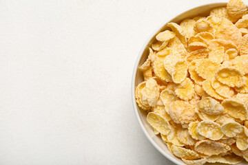 Bowl with tasty cornflakes on white background, closeup