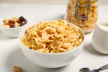 Bowl of tasty cornflakes on white background, closeup