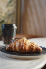 Freshly baked croissant paired with coffee on a table