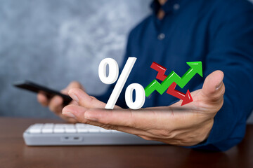 Businessman showing percentage symbol with green up and red down arrows, finance, interest rate and investment trend