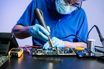Technician in gloves performs precise soldering on circuit board using hot air gun. Concept of...