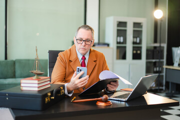 Mature Male judge in a courtroom on white table and Counselor or Male lawyer working in office. Justice and law concept