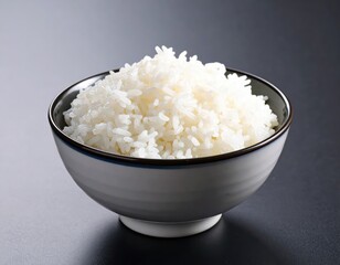 Steaming hot fluffy white rice served in modern black and white bowl on dark surface