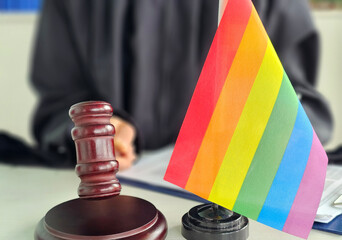 Courtroom with rainbow flag and gavel on desk highlighting LGBTQ rights discussion