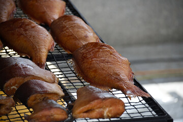 Delicious Smoked Fish Displayed on a Wire Rack at an Outdoor Market